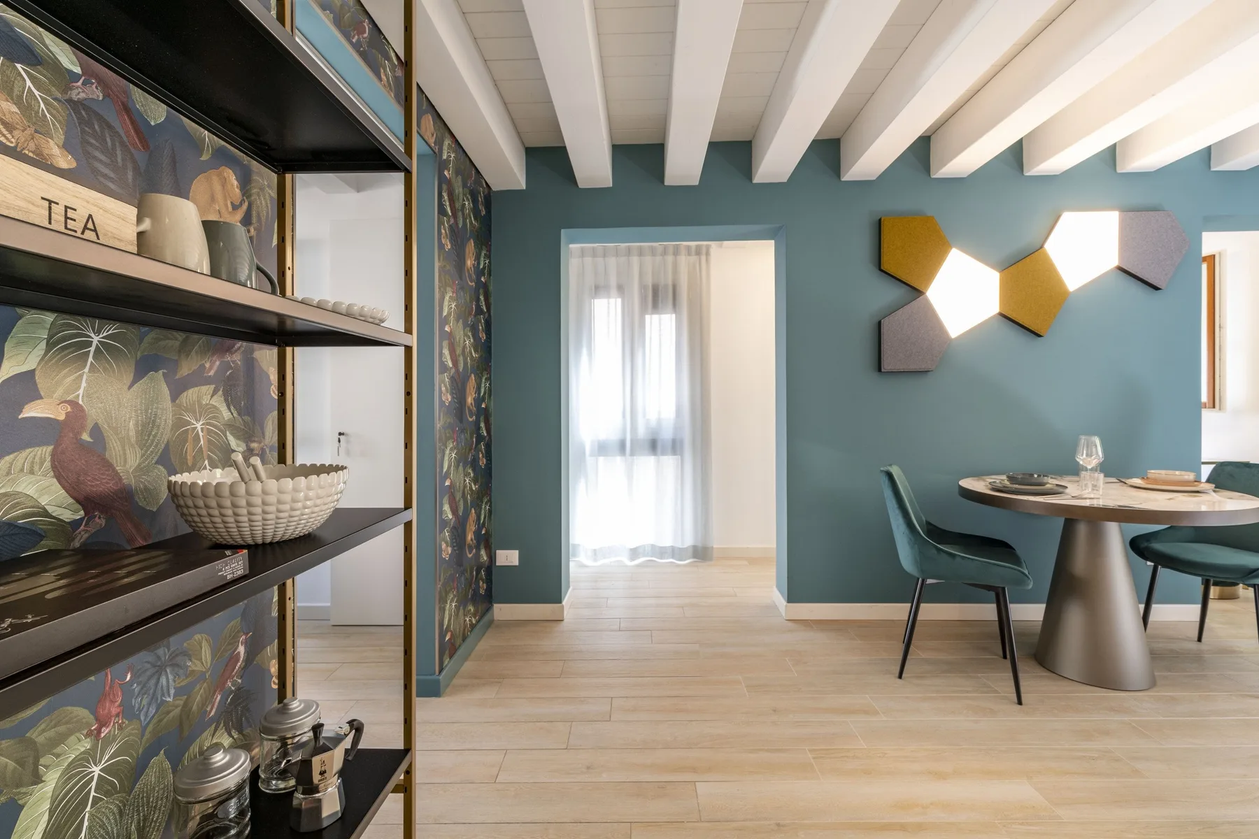 A dining area with a round table and colorful wall art.
