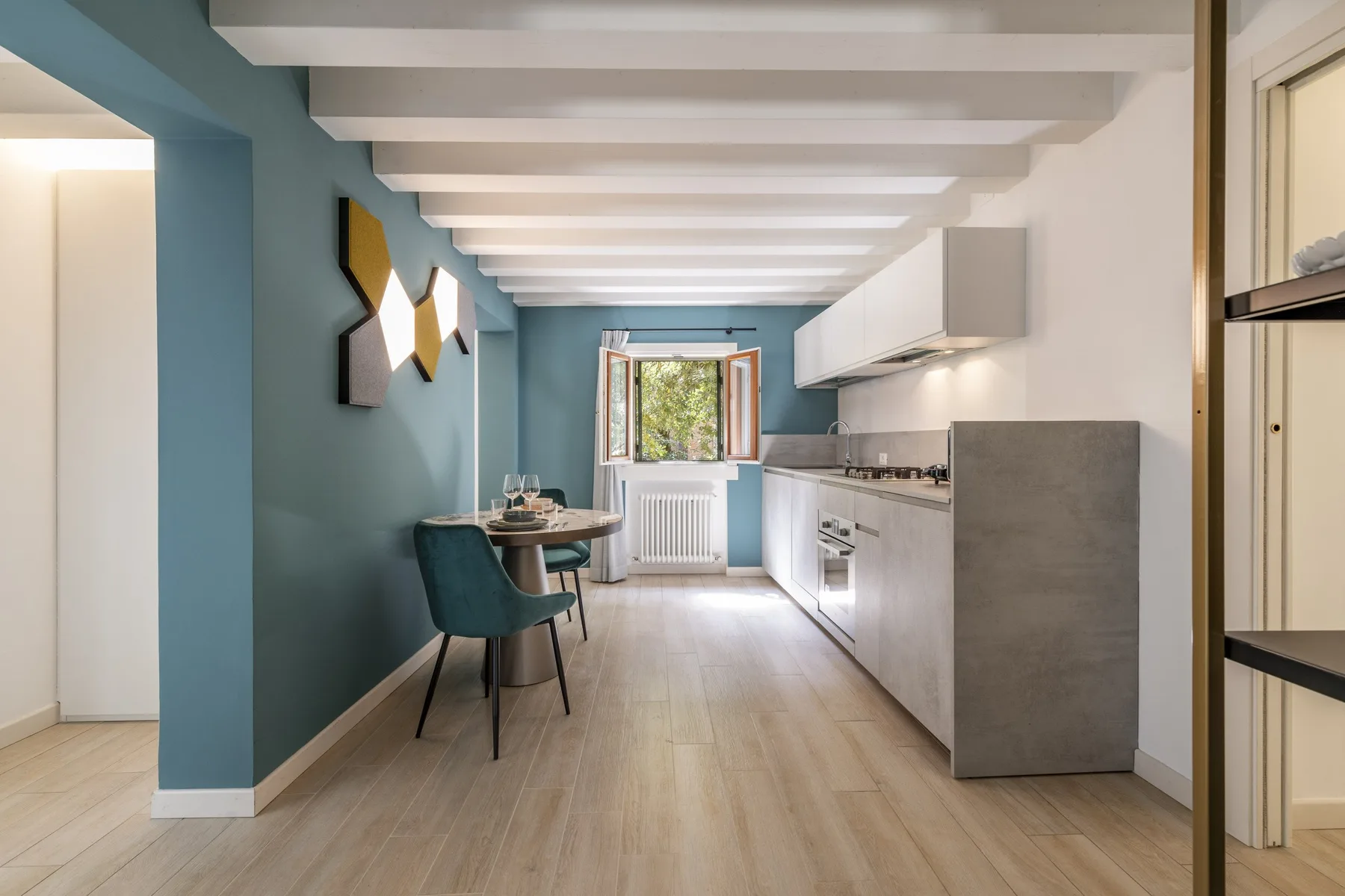A modern kitchen and dining area with a small table beside the window.