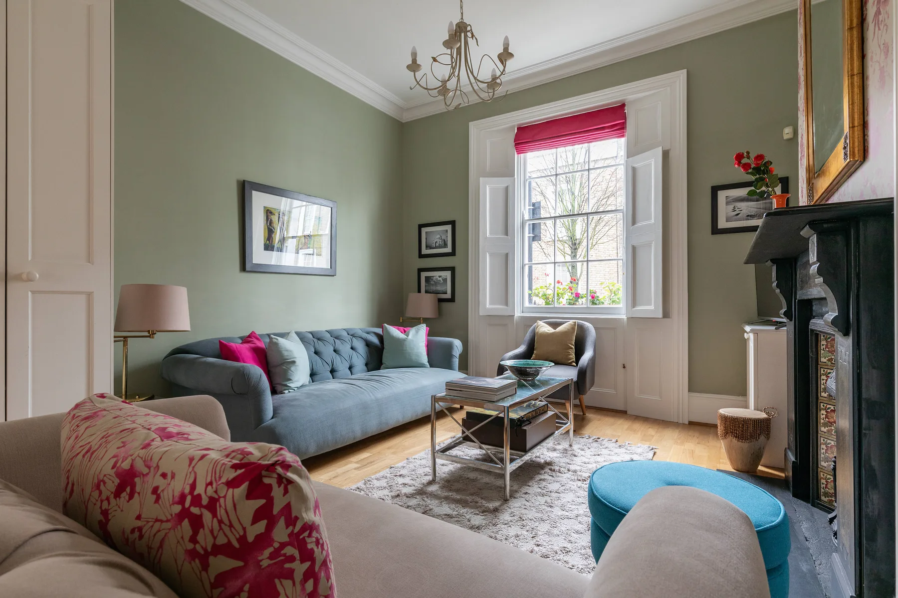 A living room with seating around a glass coffee table and a large window.
