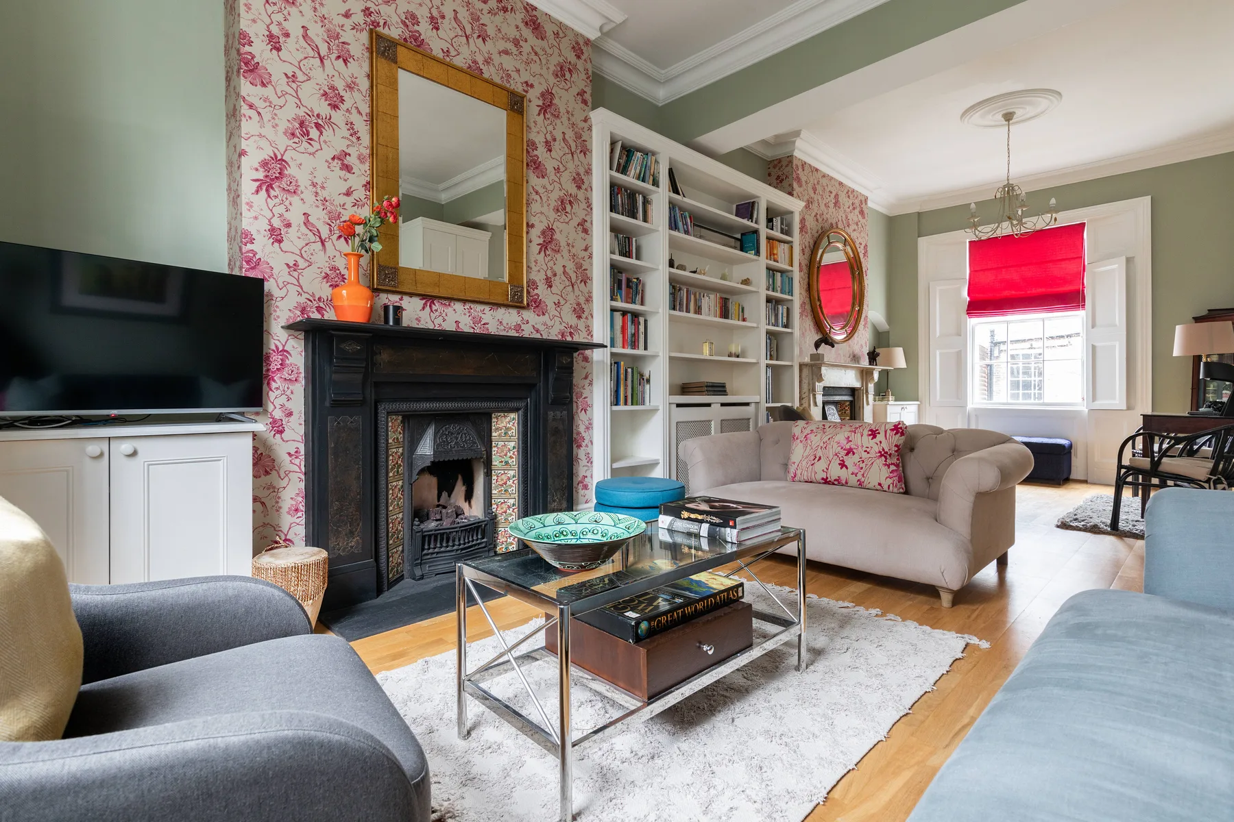 A living room with seating, bookshelves, and a fireplace.