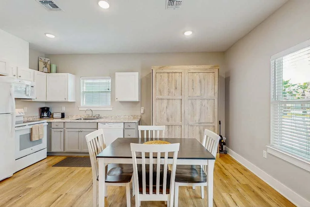 Una cocina y comedor con una mesa y gabinetes de madera.