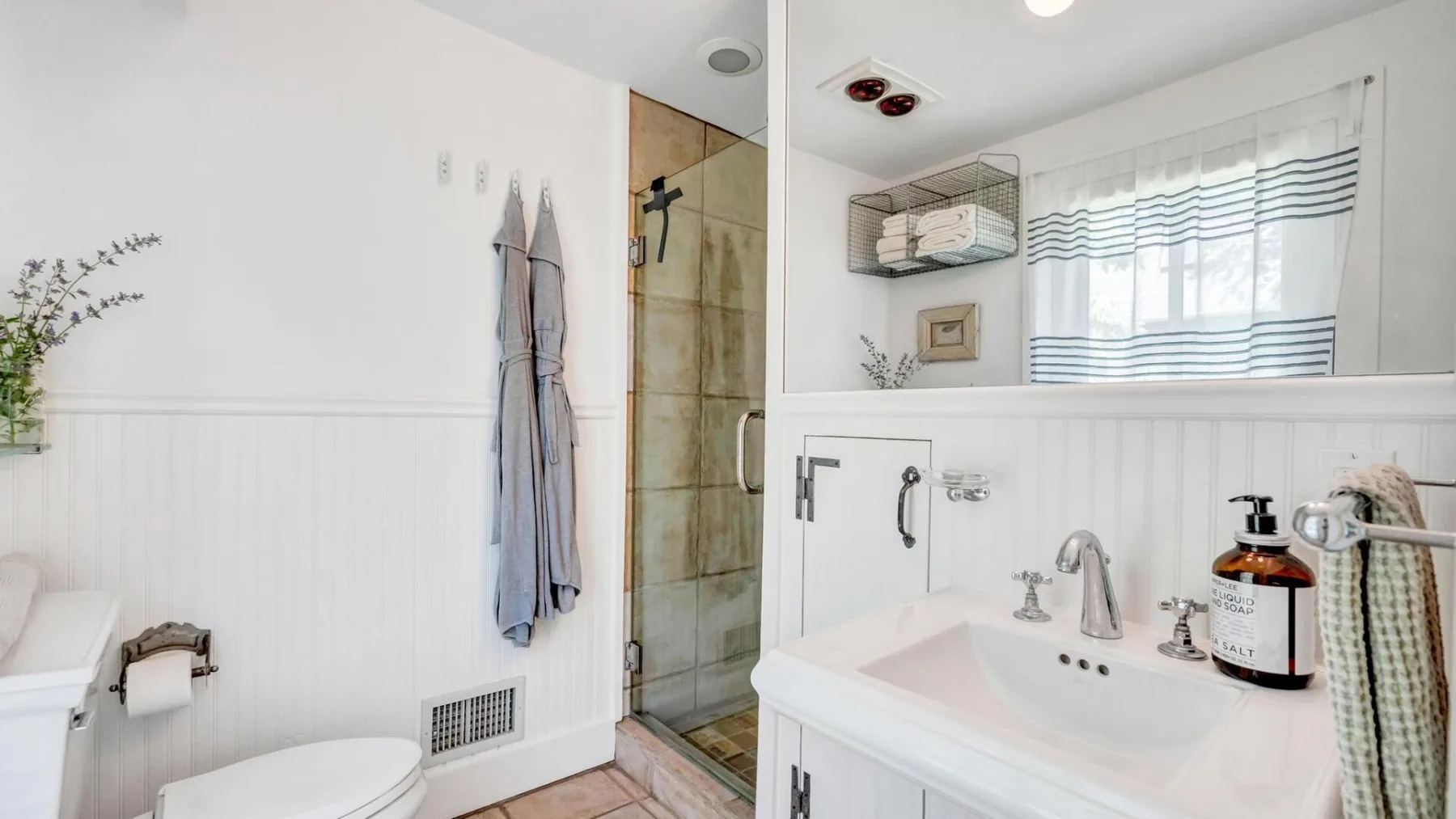 A bathroom with a sink, toilet, and glass-enclosed shower.