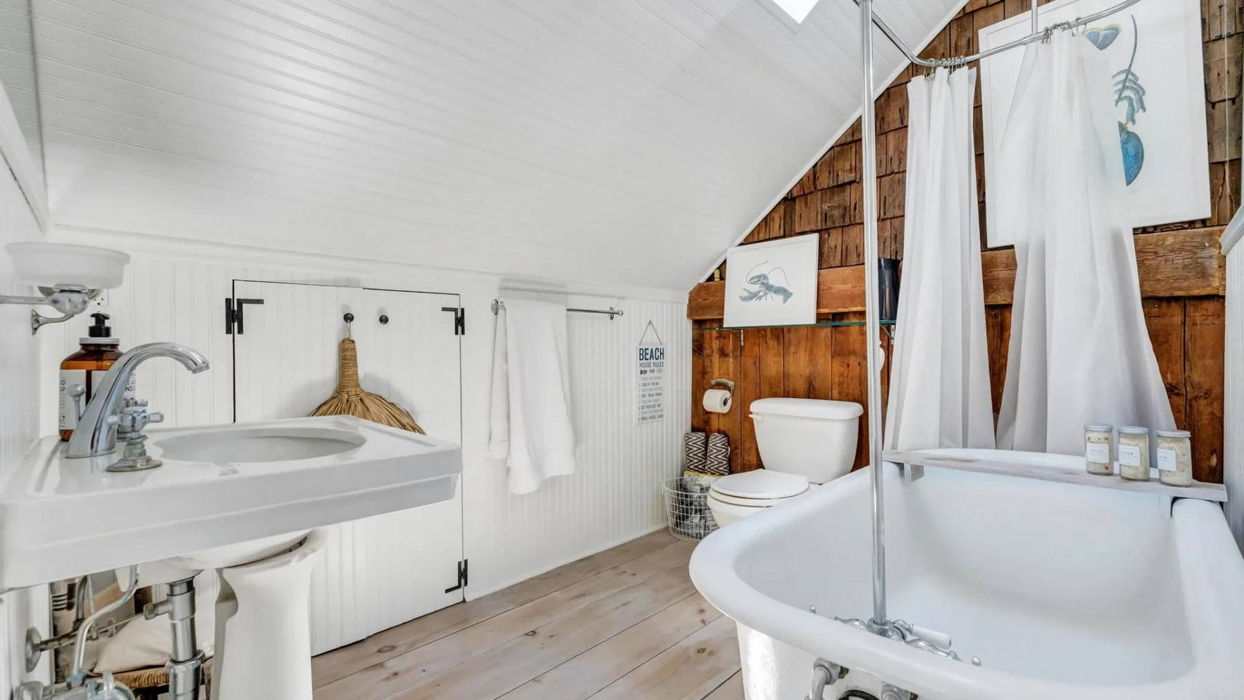 A bathroom with a bathtub, sink, and white towels.