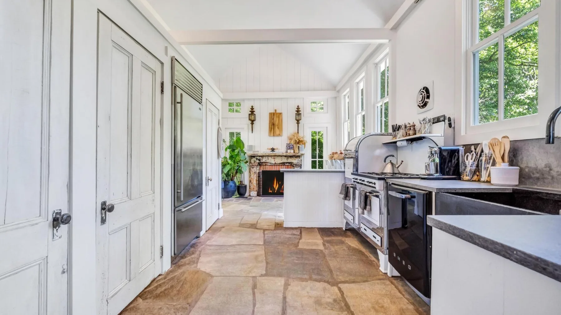 A bright kitchen with a long counter, cooking appliances, and windows.