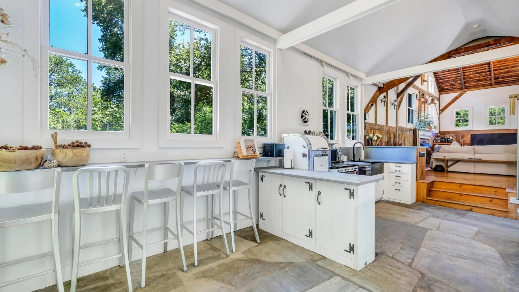 A bright kitchen with a long counter and an island beneath a high ceiling.