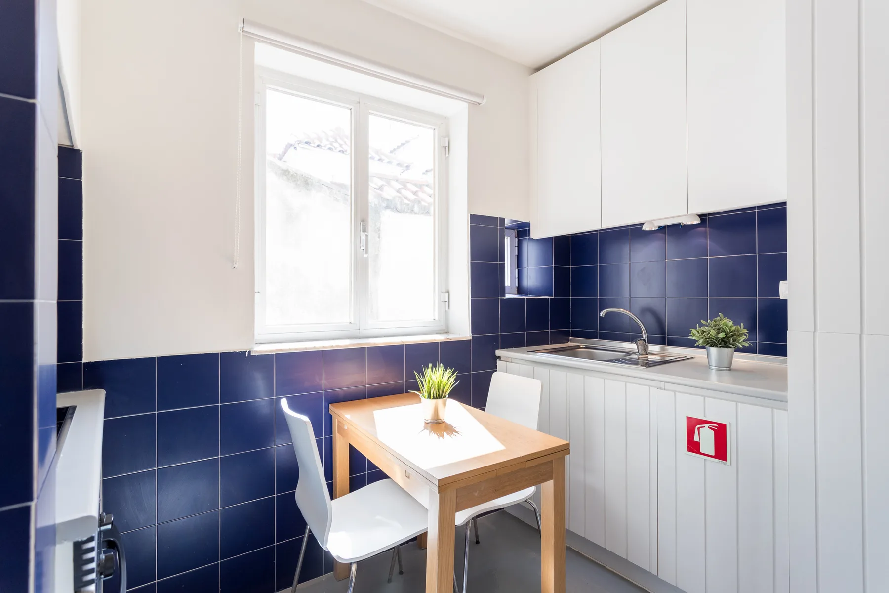 A bright kitchen with a small dining table beside the window.