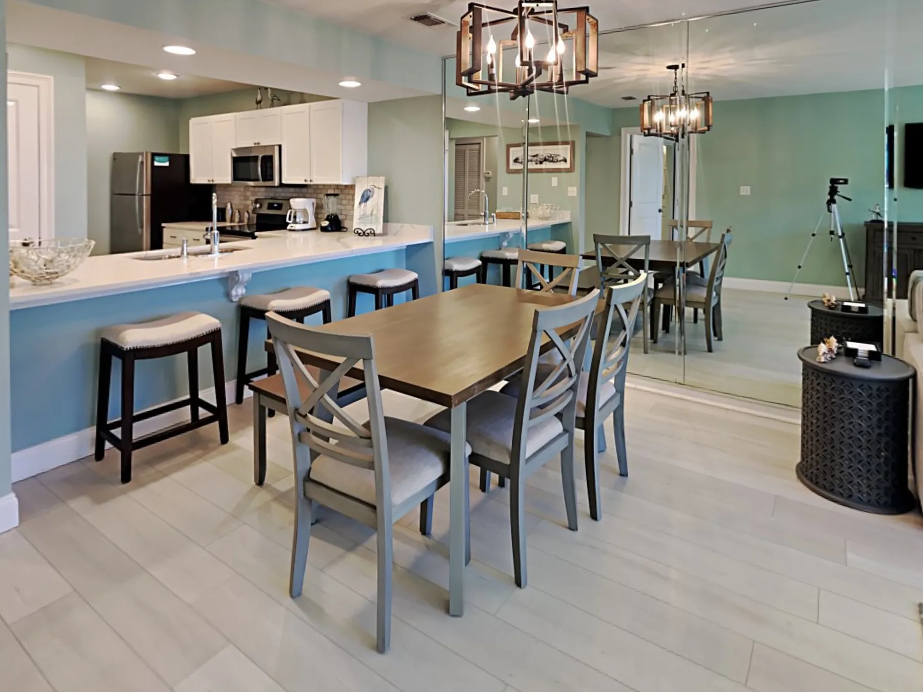 A dining area with a wooden table and chairs beside an open kitchen.