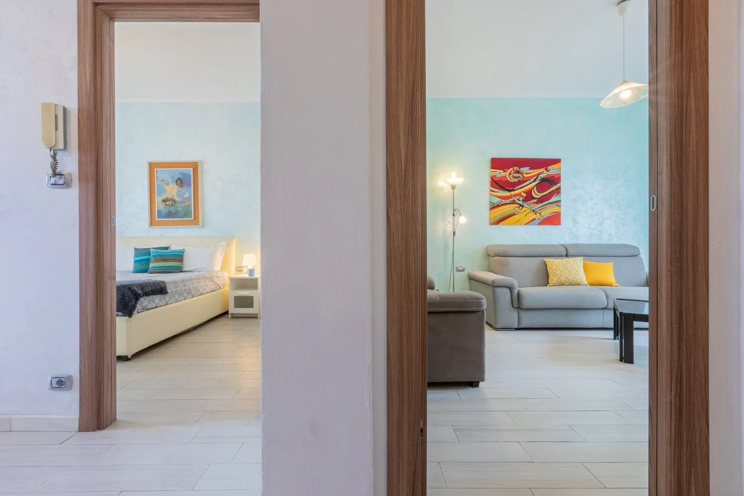 Se ven un dormitorio y una sala de estar a través de dos puertas abiertas.