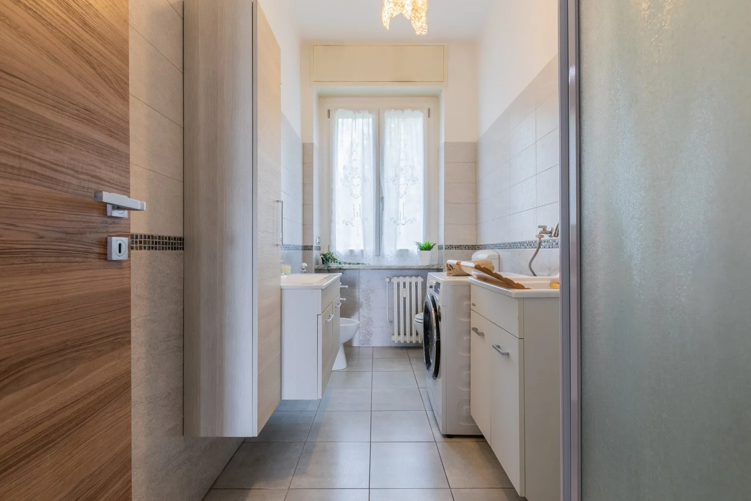 Un baño luminoso con lavabo, bañera y ventana.