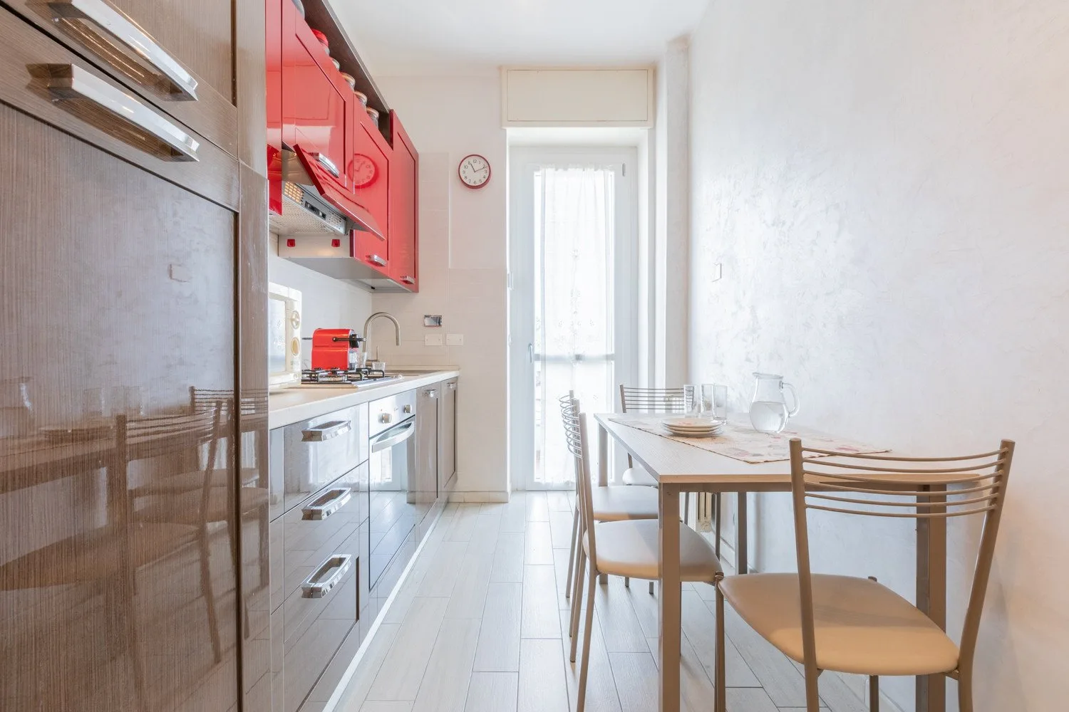 Una cocina luminosa con comedor y una mesa junto a la encimera.