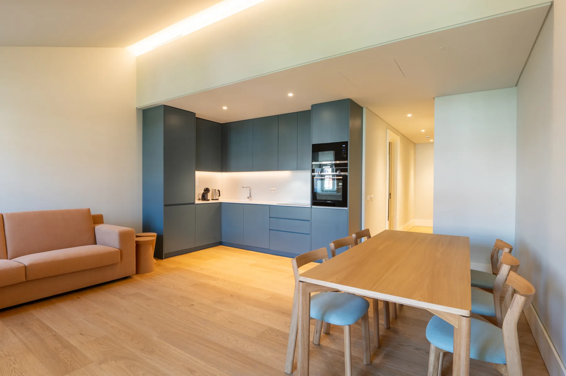 Una sala-comedor de concepto abierto con una cocina azul.