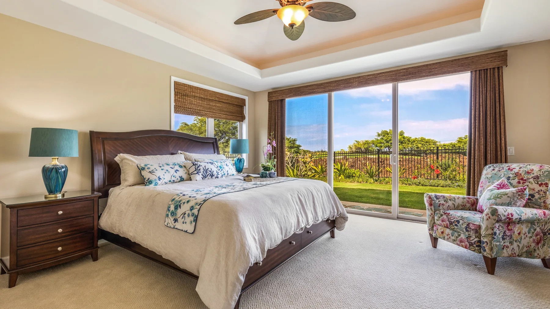 Un dormitorio con una cama grande y puertas corredizas de vidrio con vista al jardín.