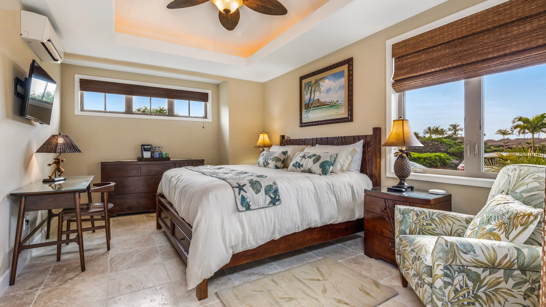 Dormitorio con cama, mesitas de noche y vistas frondosas por la ventana.