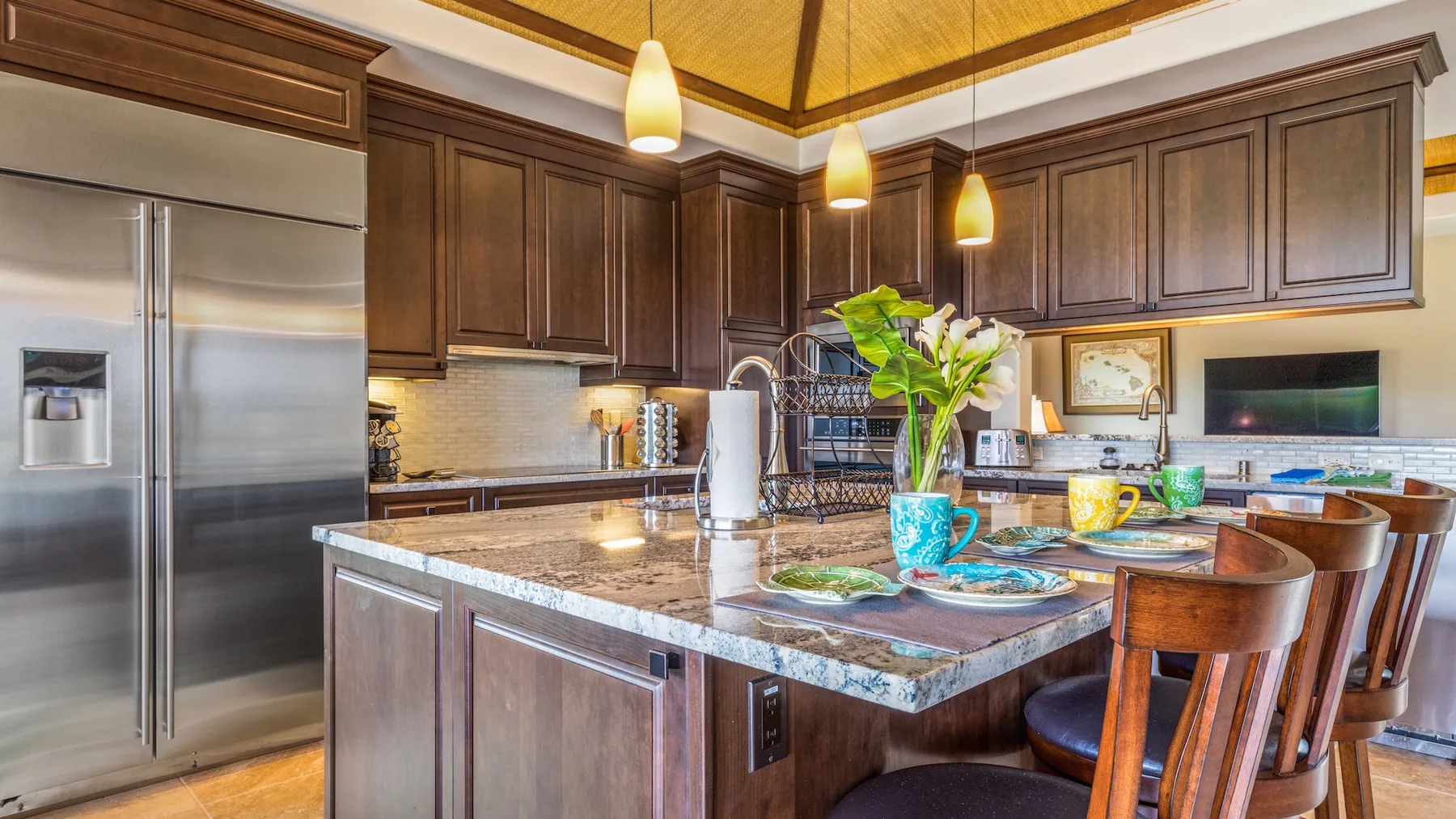 Una cocina amplia con gabinetes de madera oscura y una isla central con platos.
