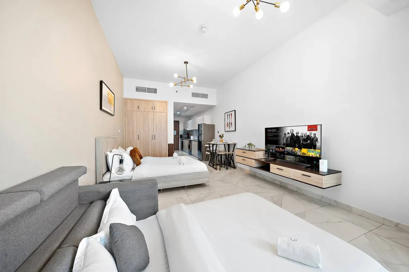 Una sala luminosa con asientos, camas y un televisor.