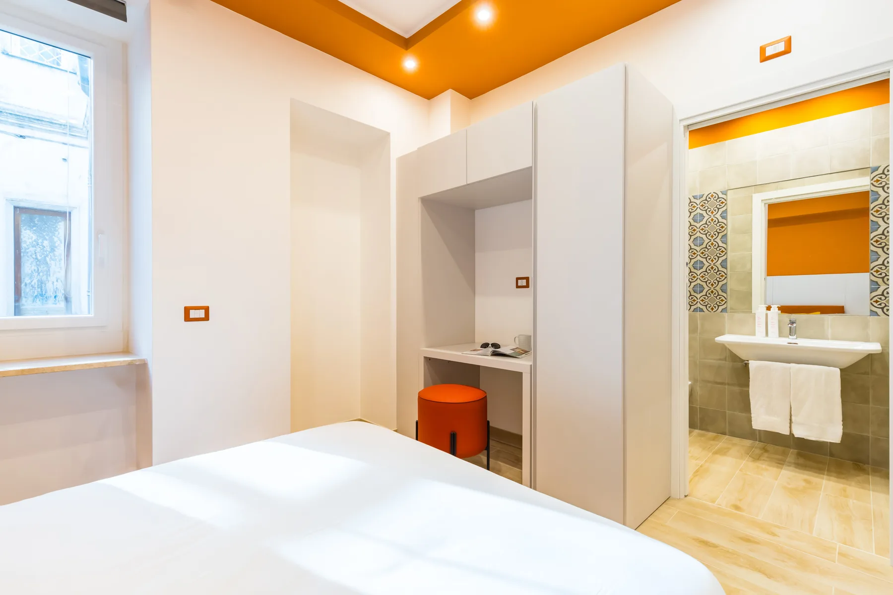 A bedroom with a bed and an open doorway to a bathroom.