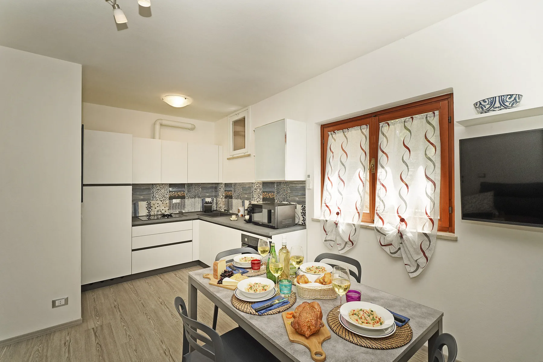 Una cocina luminosa con comedor y una mesa preparada para comer.