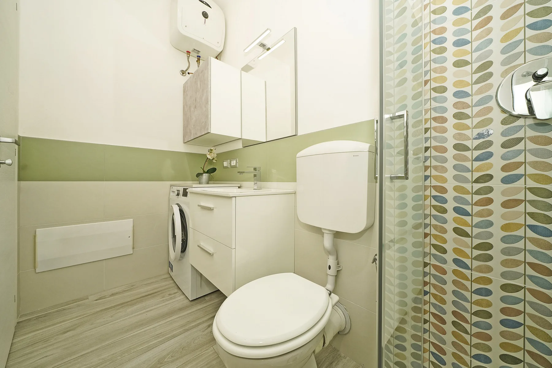 Un baño con inodoro, lavabo y cortina de ducha estampada.