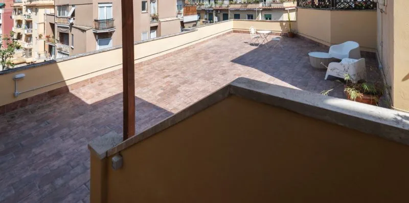 Una terraza en la azotea con suelo pavimentado y asientos al aire libre.