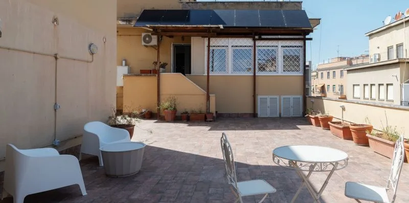 Una terraza en la azotea con asientos al aire libre y plantas en macetas.