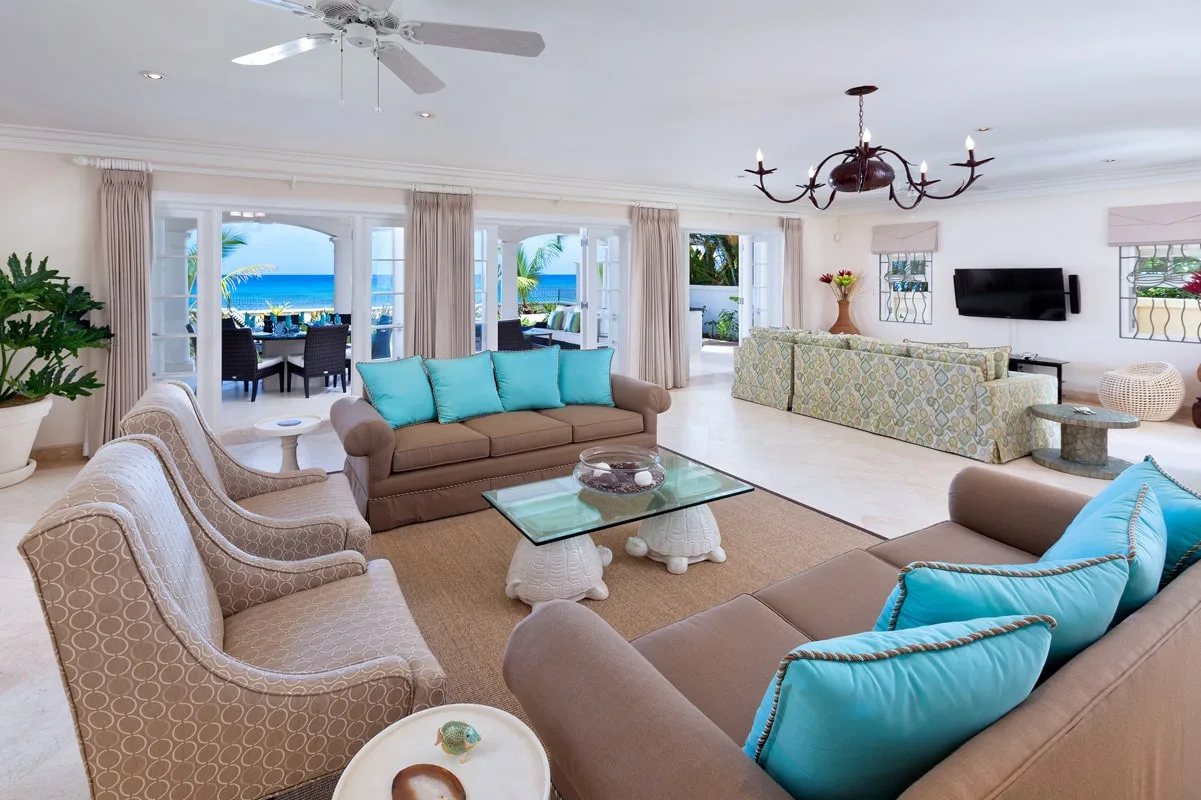 A bright living room with seating arranged around a glass coffee table.