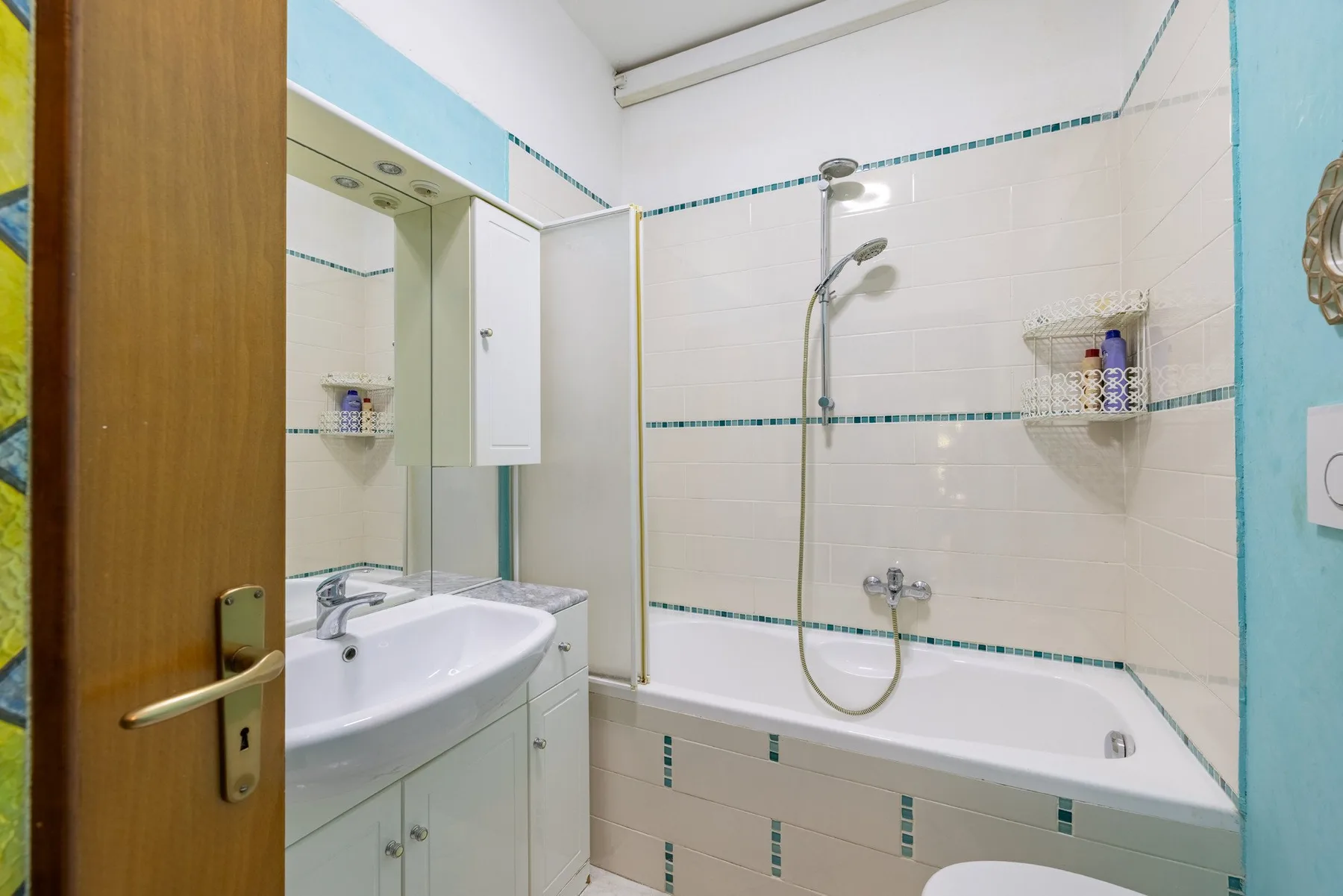 A tiled bathroom with a bathtub, shower, and sink.