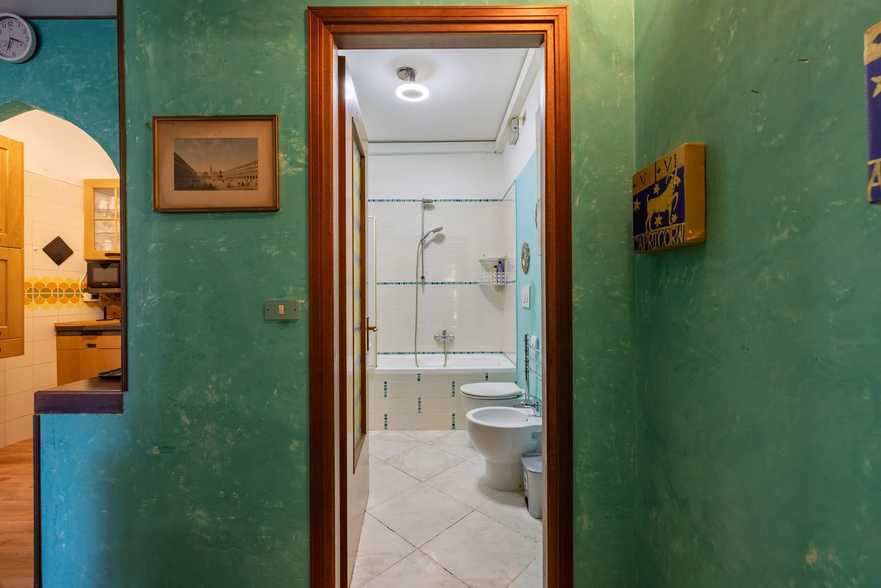 A bathroom is visible through an open doorway, with a sink and toilet.