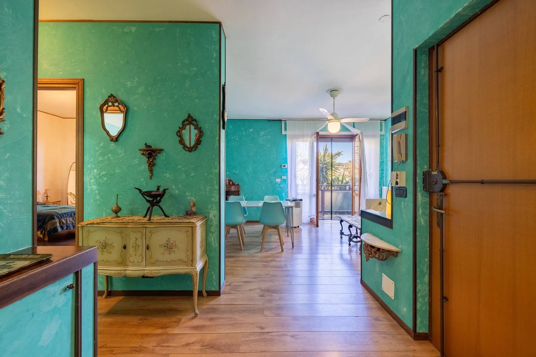 A colorful interior hallway opens onto a dining area with a table and chairs.