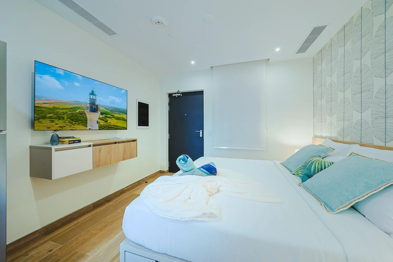 Relax in your serene bedroom with coastal-inspired décor, plush bedding, a large flat-screen TV, and soothing blue-green accents. Perfect for unwinding after exploring.