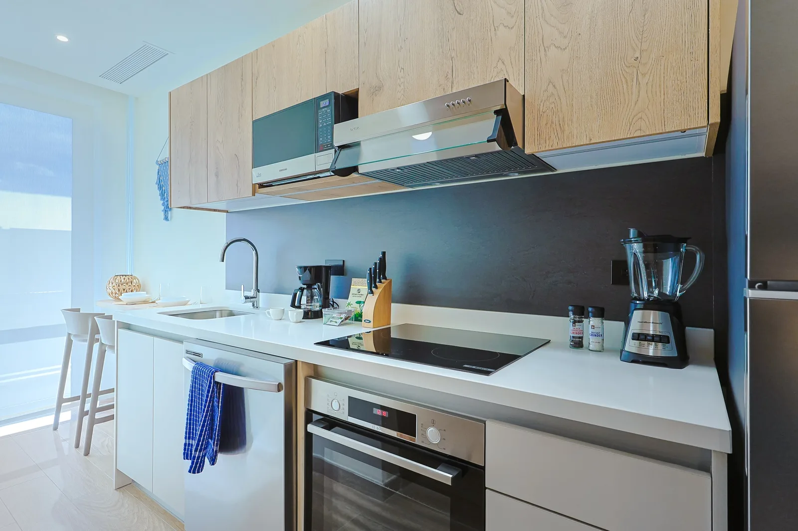 Picture yourself whipping up breakfast in this sleek, modern kitchen, fully equipped with quality appliances, gleaming countertops, and all the essentials for your culinary adventures.