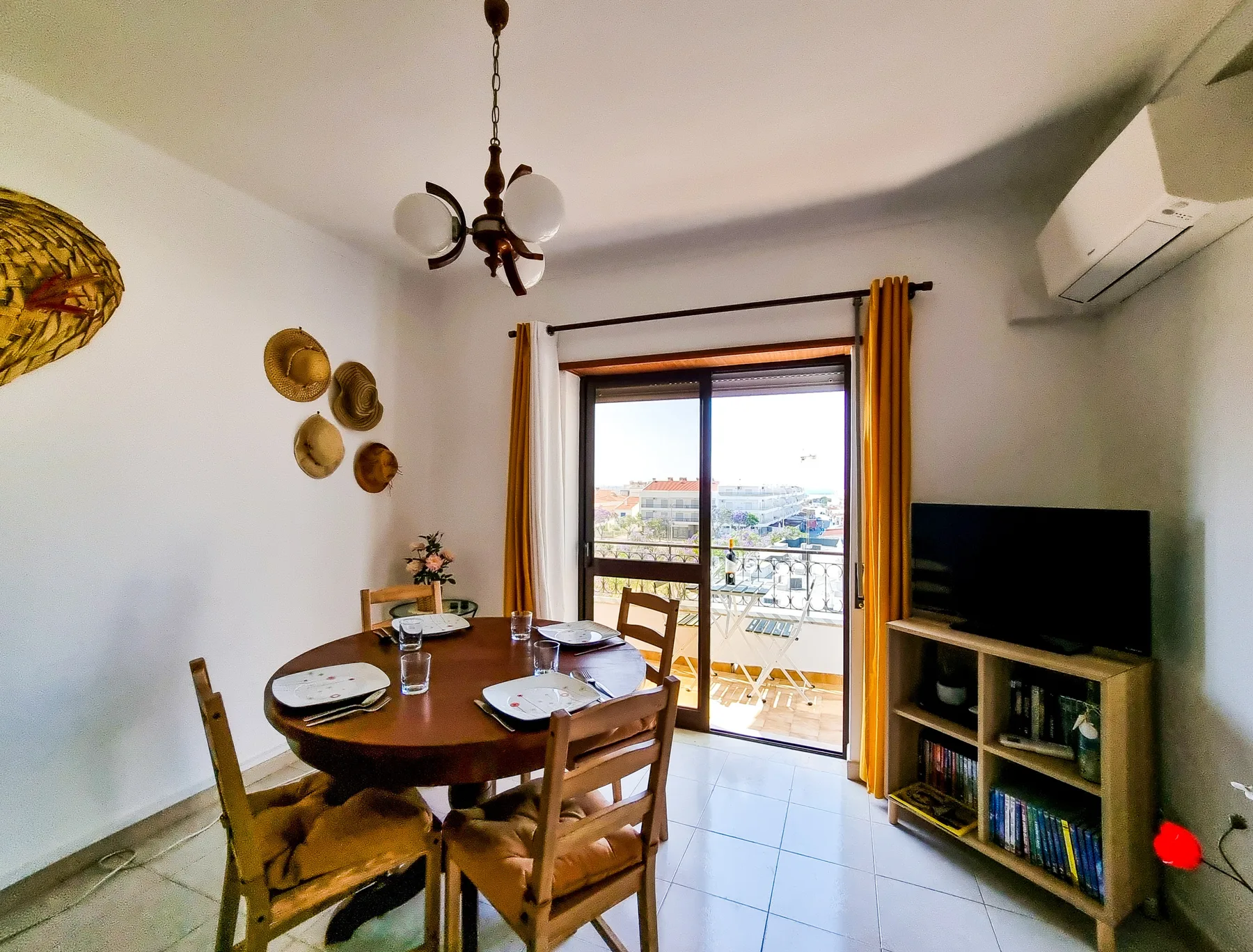 Comedor con una mesa de madera junto a puertas de vidrio que dan a un balcón.