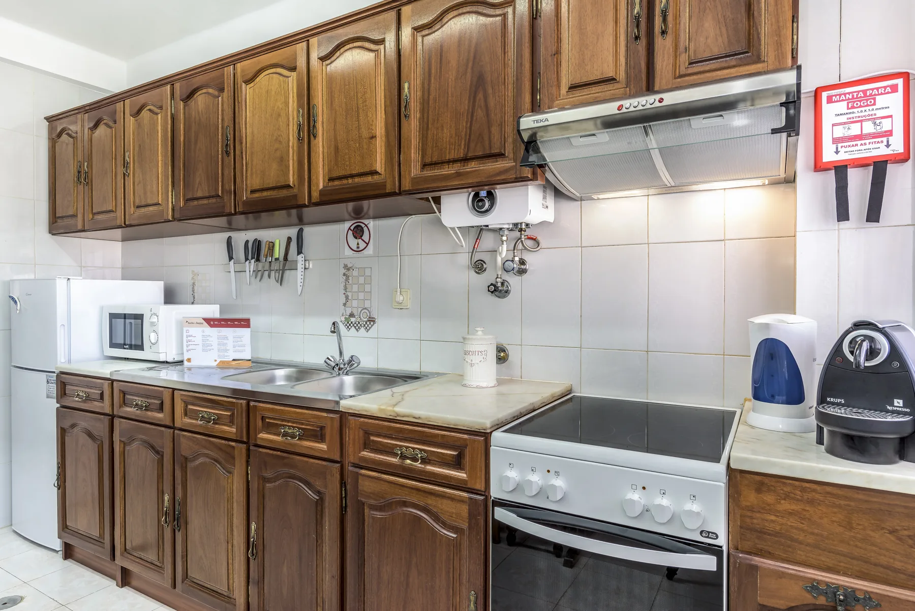 Una cocina con azulejos, armarios de madera, una encimera y una estufa.