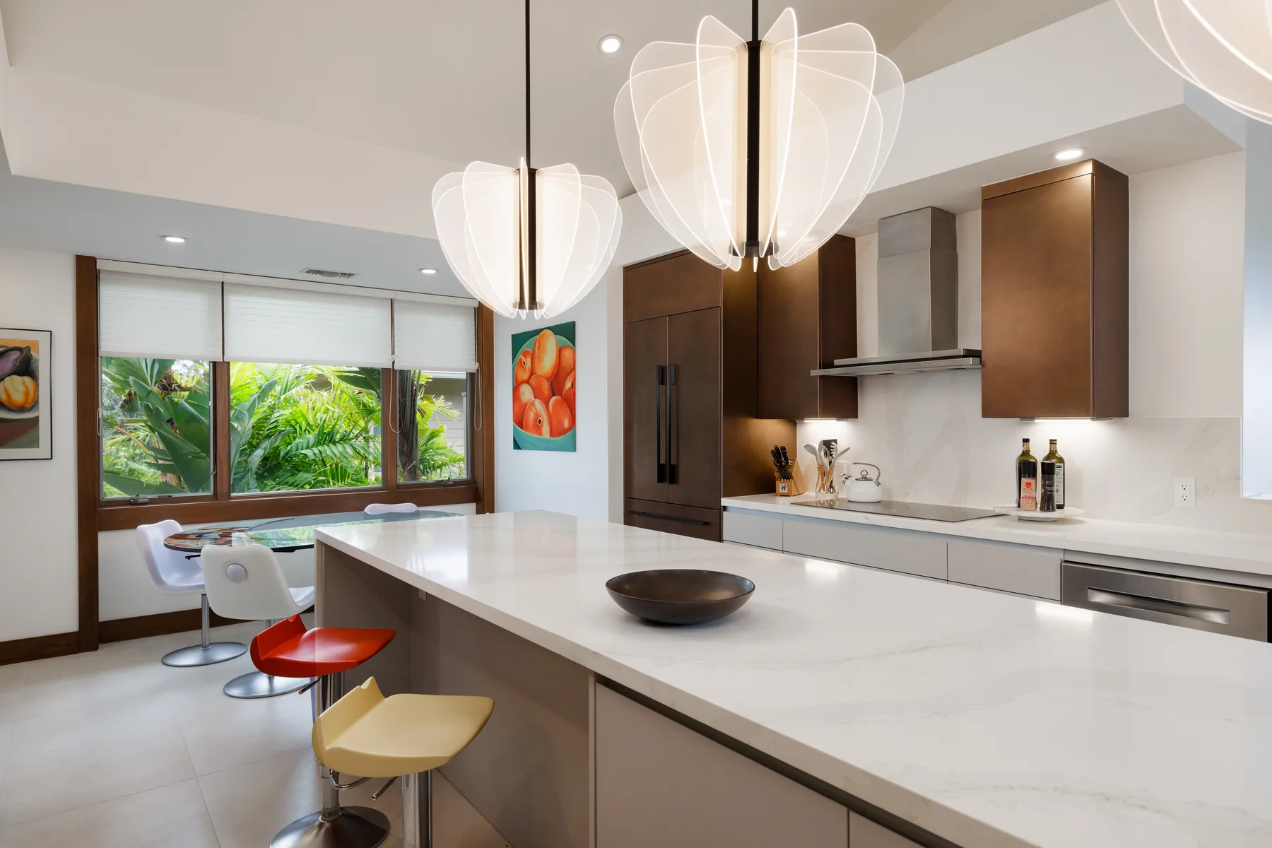 Una cocina moderna con una gran isla y asientos junto a amplias ventanas.