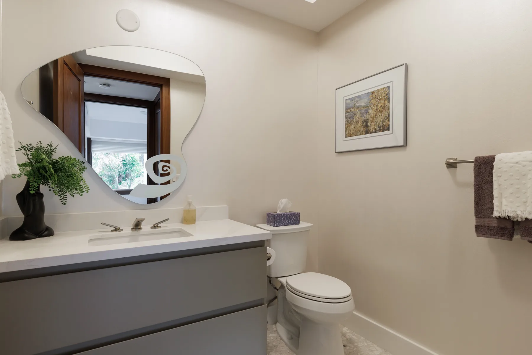 Un baño con lavabo, espejo e inodoro.