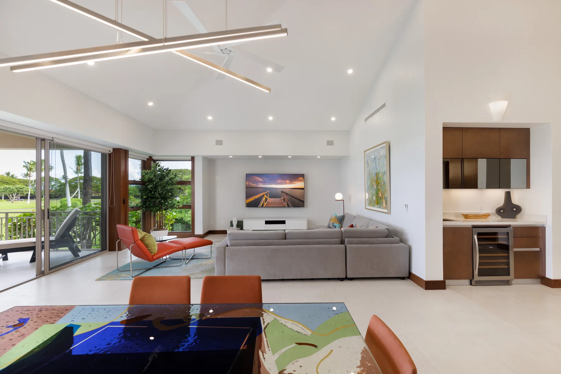 Una sala de estar luminosa da a un patio acristalado, con una mesa de comedor en primer plano.