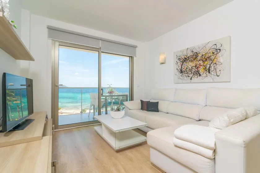 Living room with seating, a coffee table, and sliding glass doors overlooking the sea.