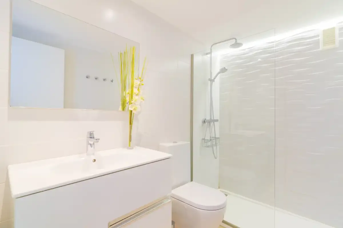 A bright bathroom with a bathtub, sink, and glass shower.