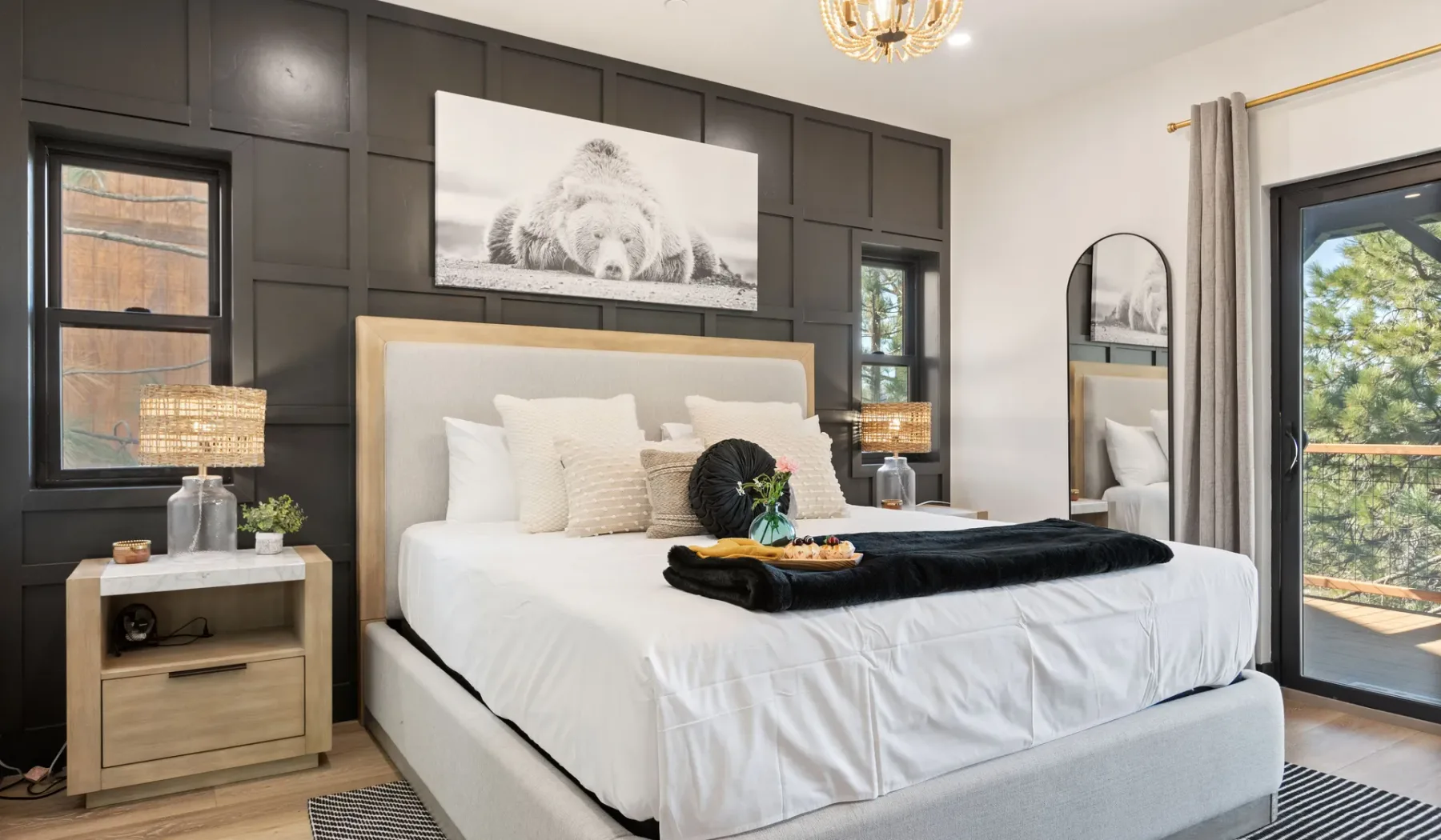 Un dormitorio con una cama grande vestida con sábanas blancas y paredes con paneles oscuros.