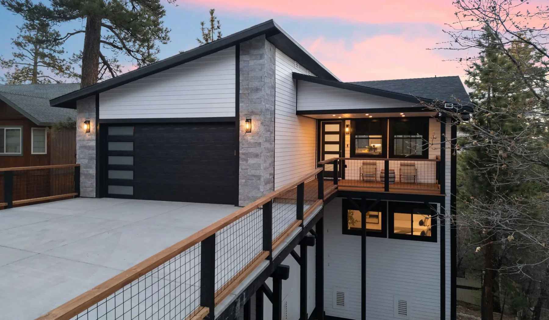 Exterior de una casa moderna con una amplia entrada y un balcón cubierto.