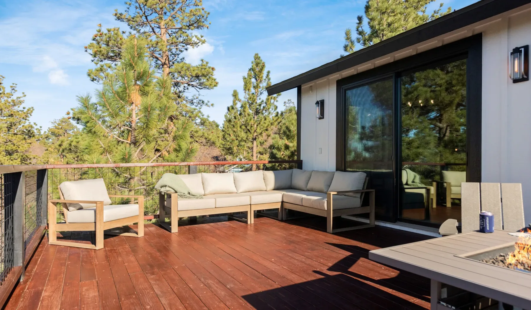 Una terraza exterior con asientos y vistas a los árboles cercanos.