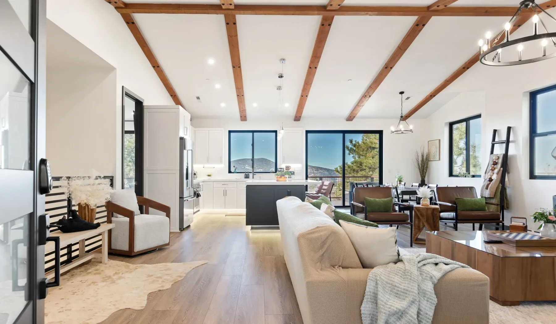Sala de estar y cocina de concepto abierto, con asientos y grandes ventanas.