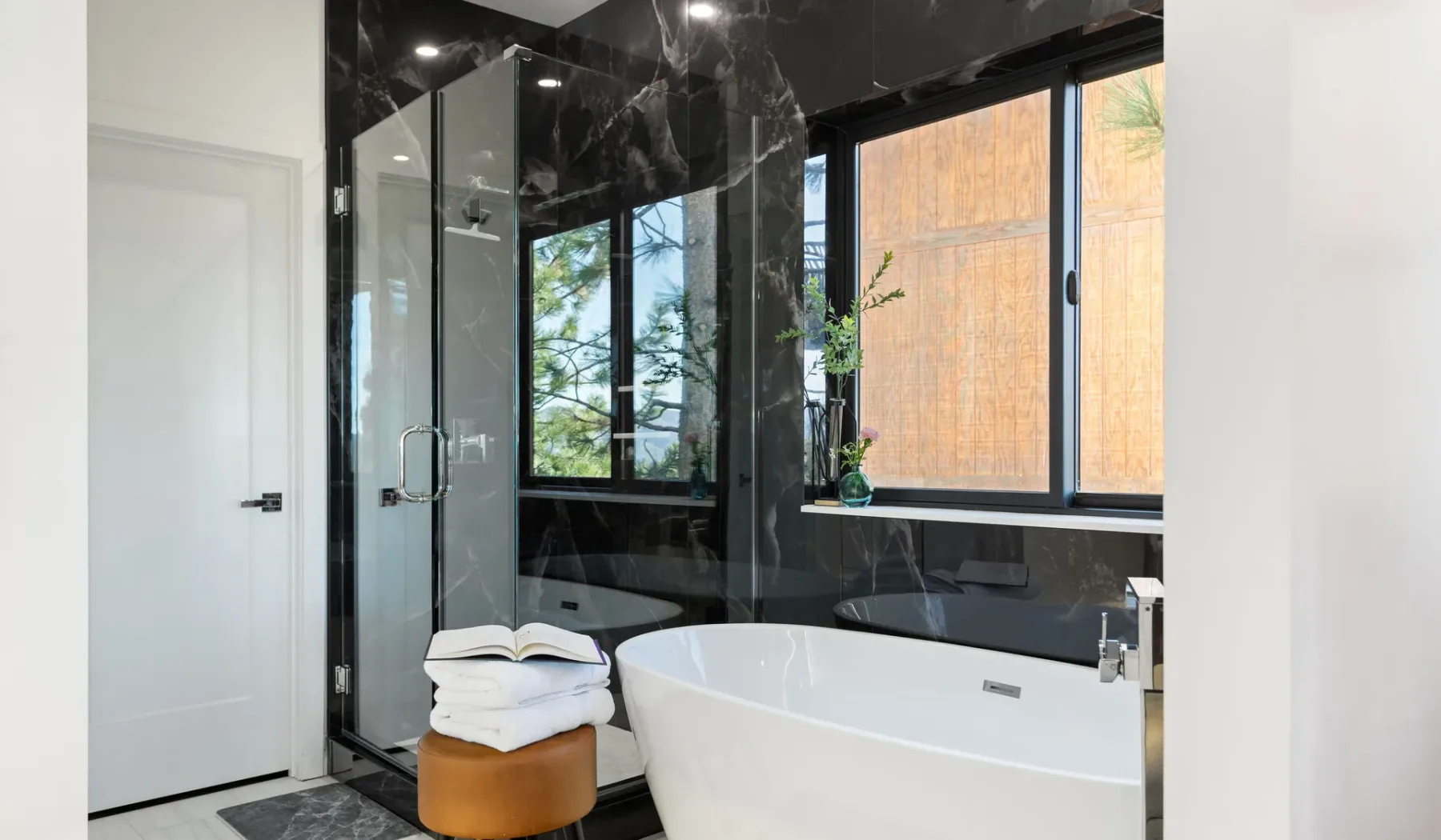 Un baño moderno con una ducha de vidrio y una bañera exenta.