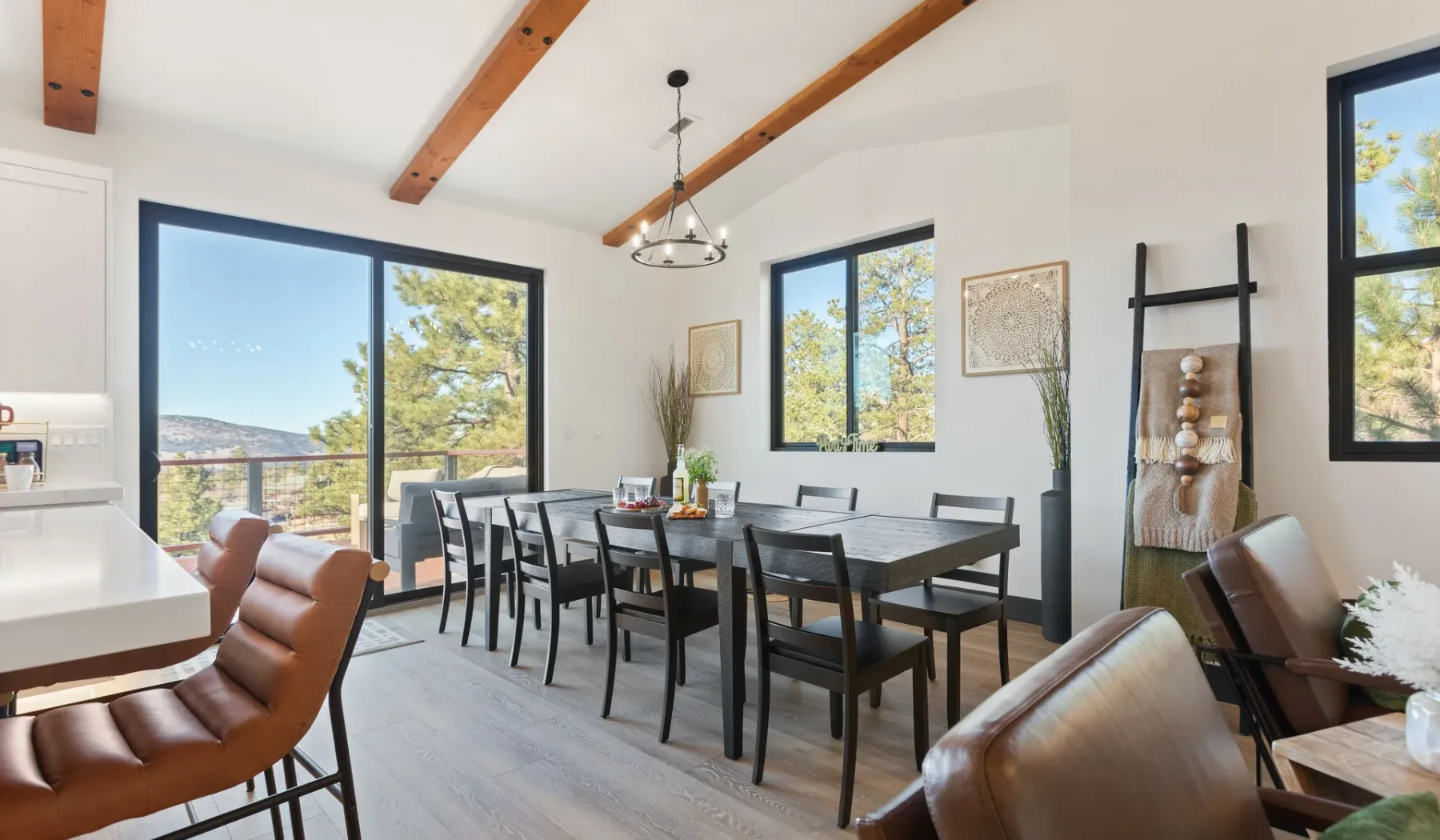 Un comedor luminoso con una mesa larga, asientos y grandes ventanas.