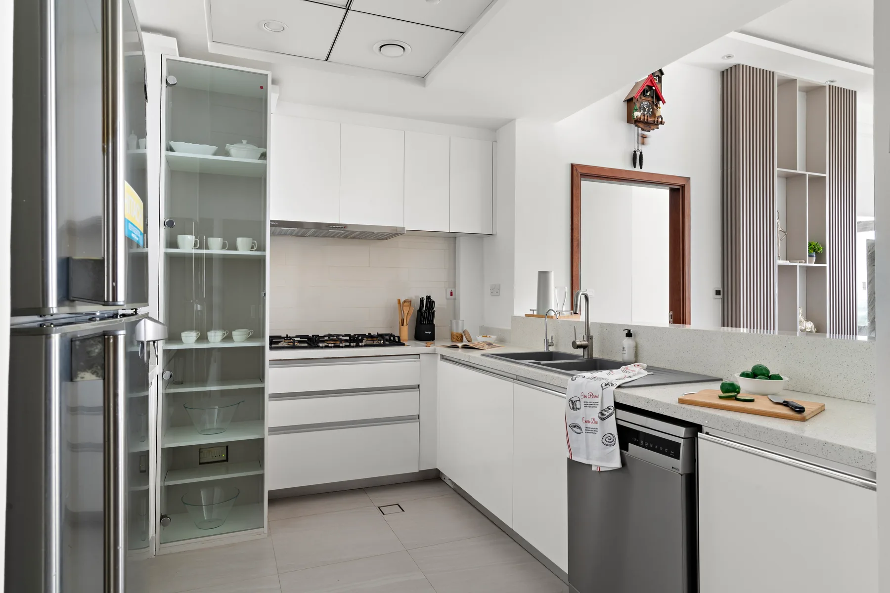 A bright kitchen with white cabinets, a cooking area, and a sink.