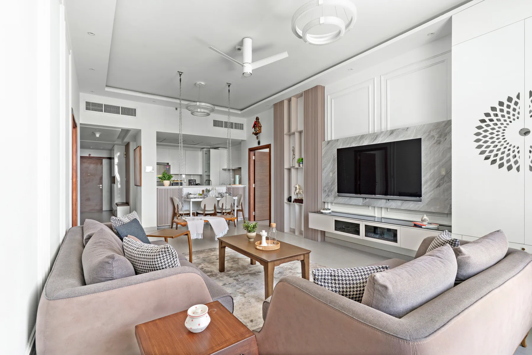 A bright living room with seating, a coffee table, and a television.