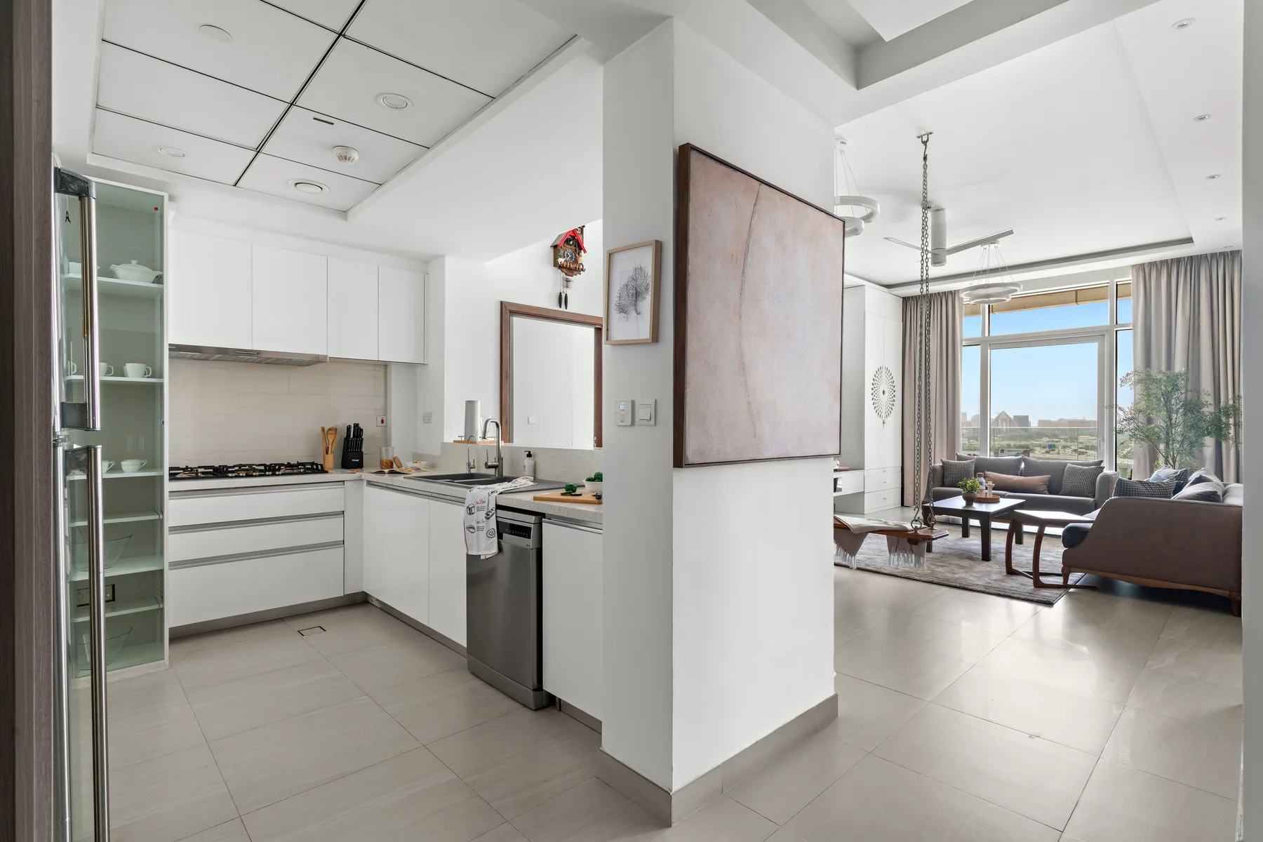 An open-plan kitchen and living area with a dining table and large windows.