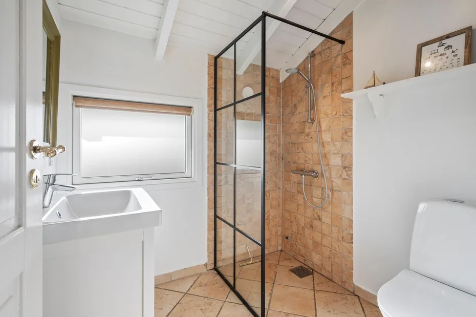 Un baño luminoso con lavabo y ducha.