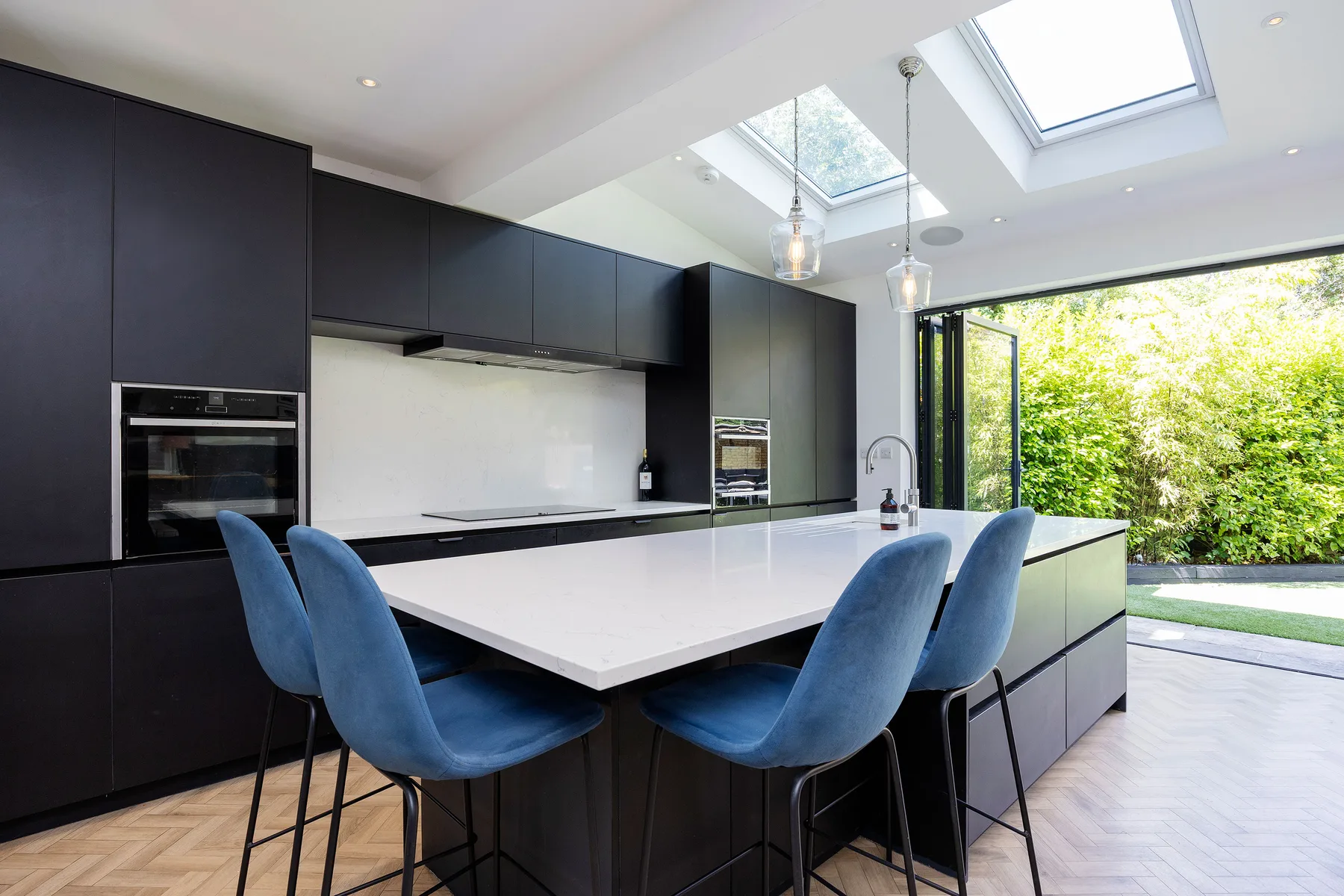 A modern kitchen with a large island and blue seating.