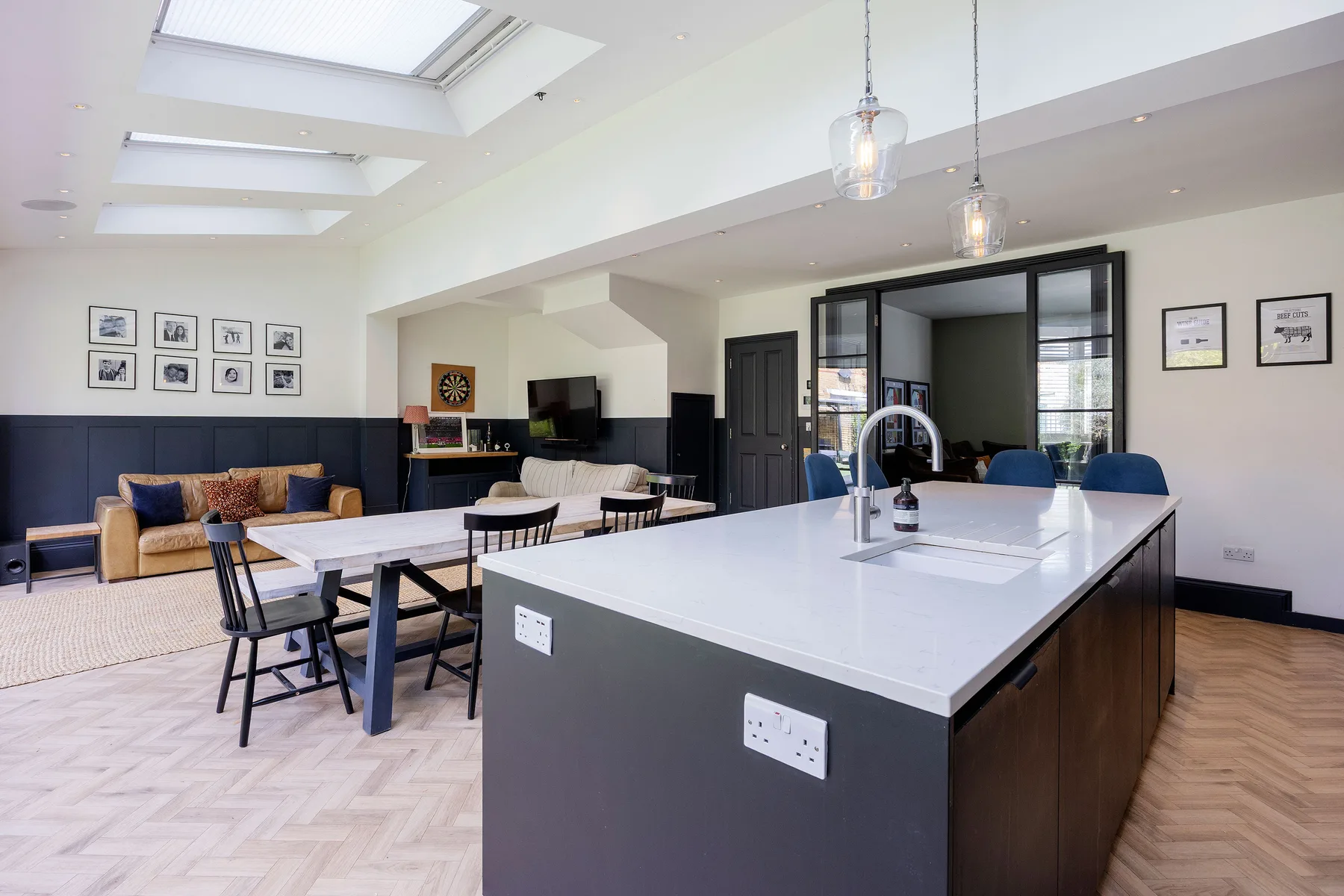 An open-plan kitchen and dining area with a large island and skylights.
