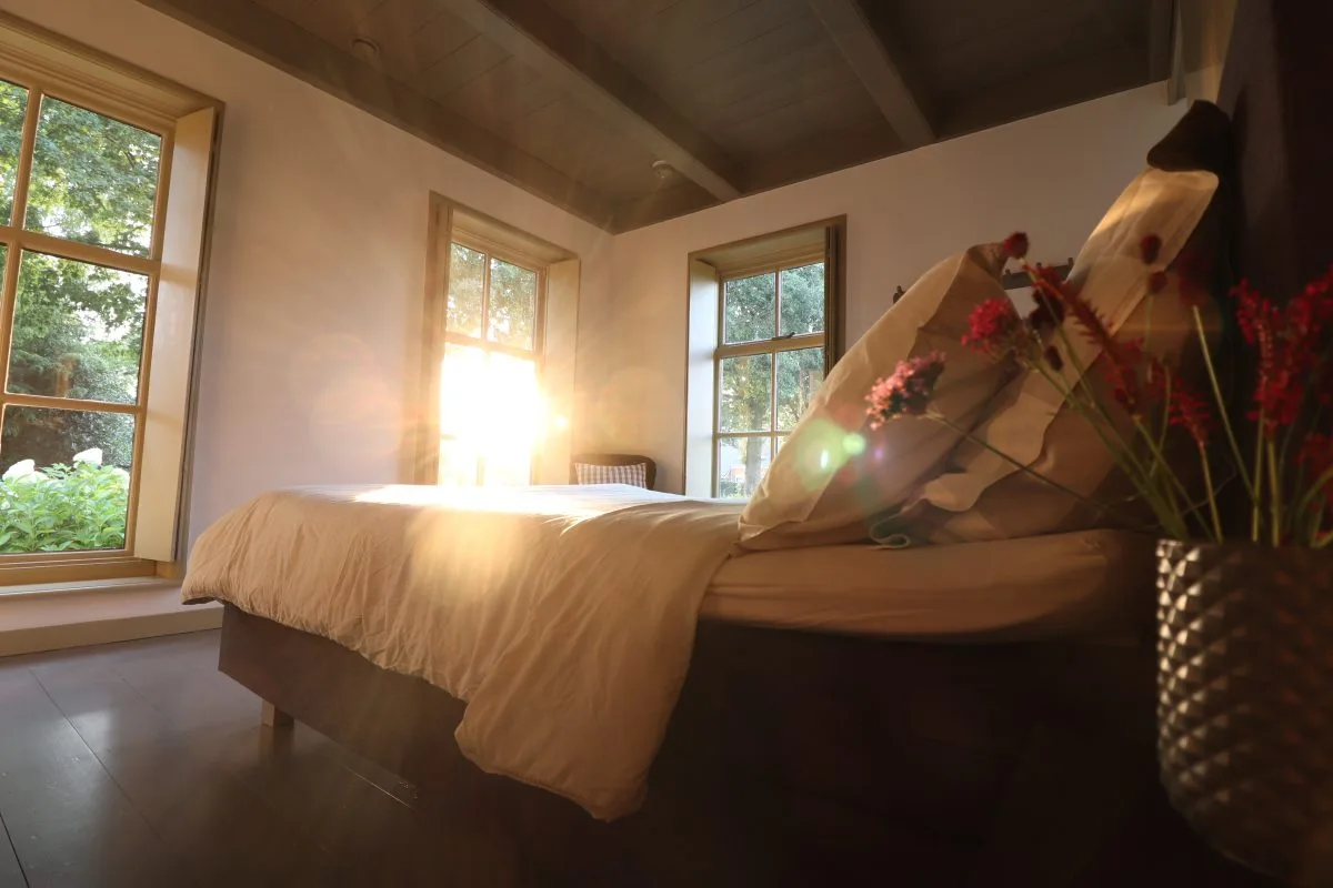 Dormitorio con cama doble y cortina o estor opaco